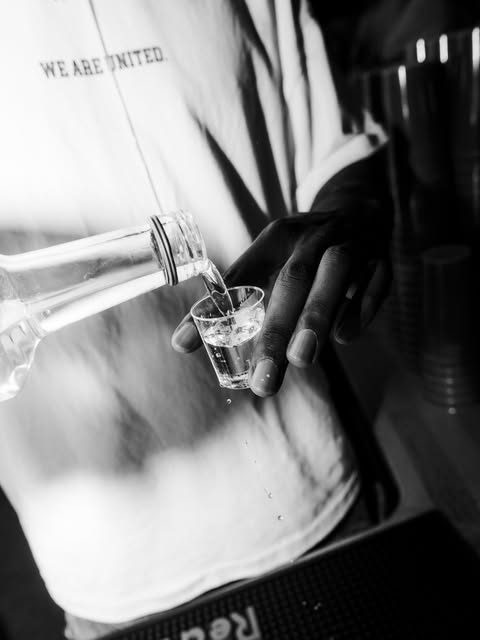 A drink being poured at UNITED, with a WE ARE UNITED shirt.